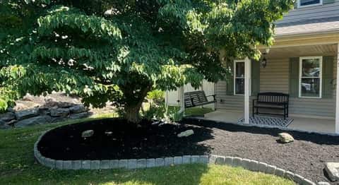 Fresh mulch installation around a landscaped planting bed